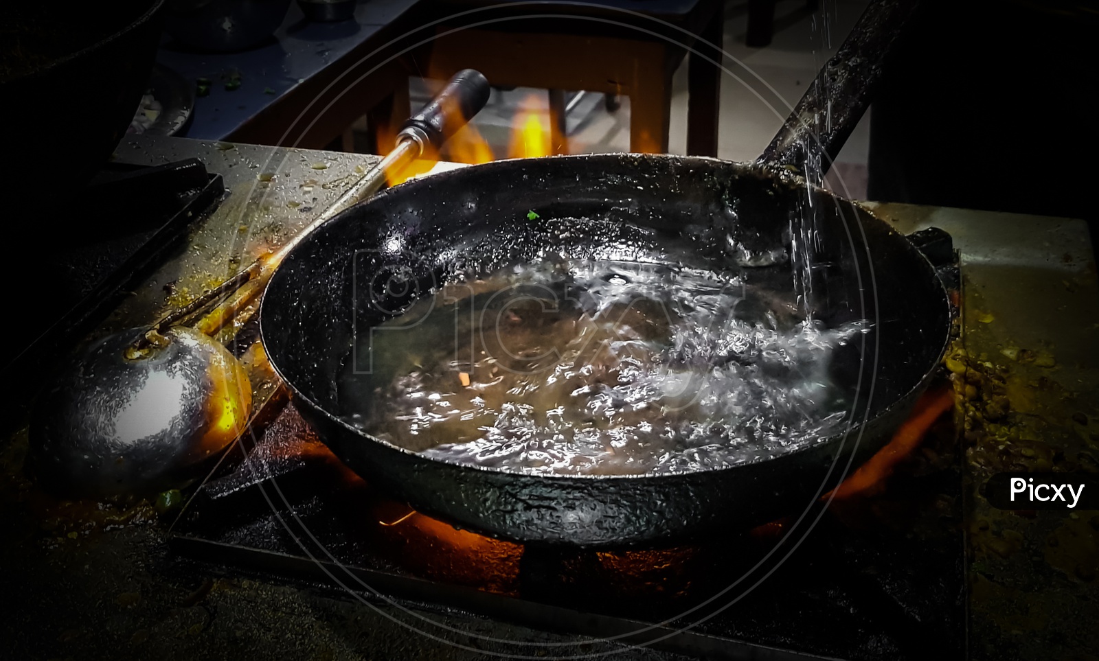 Cooking Tadka Fry In A Frying Pan At A Road Side Food Corner On A Stove Over Flames