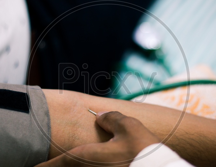 Needle For Blood Collection Inserted In Arm Of Patient By Attendant