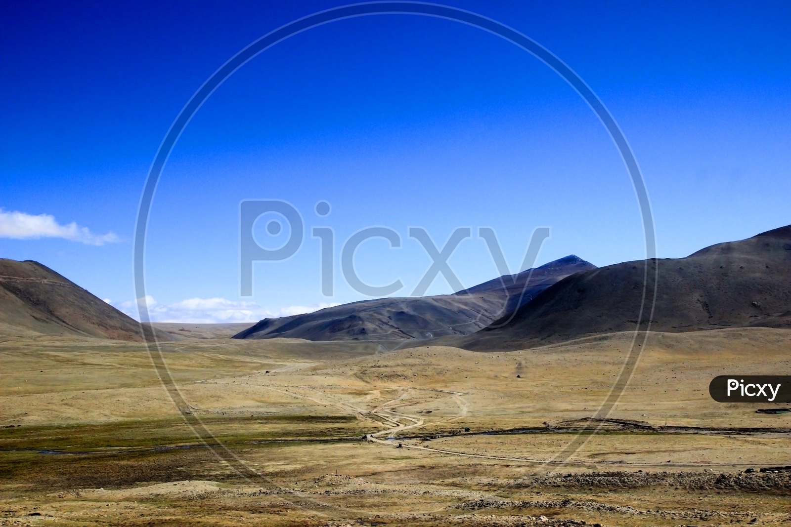 Wide Panoramic View Of A Dry Barren Desert Land With Roads Mountains And Blue Sky