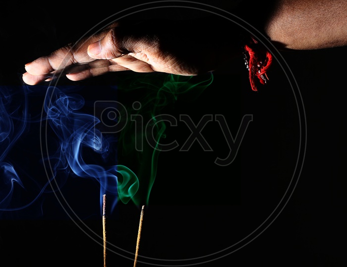 Hand Over Coloured Smoke Coming Out Of Incense Sticks. Abstract Smoke Art