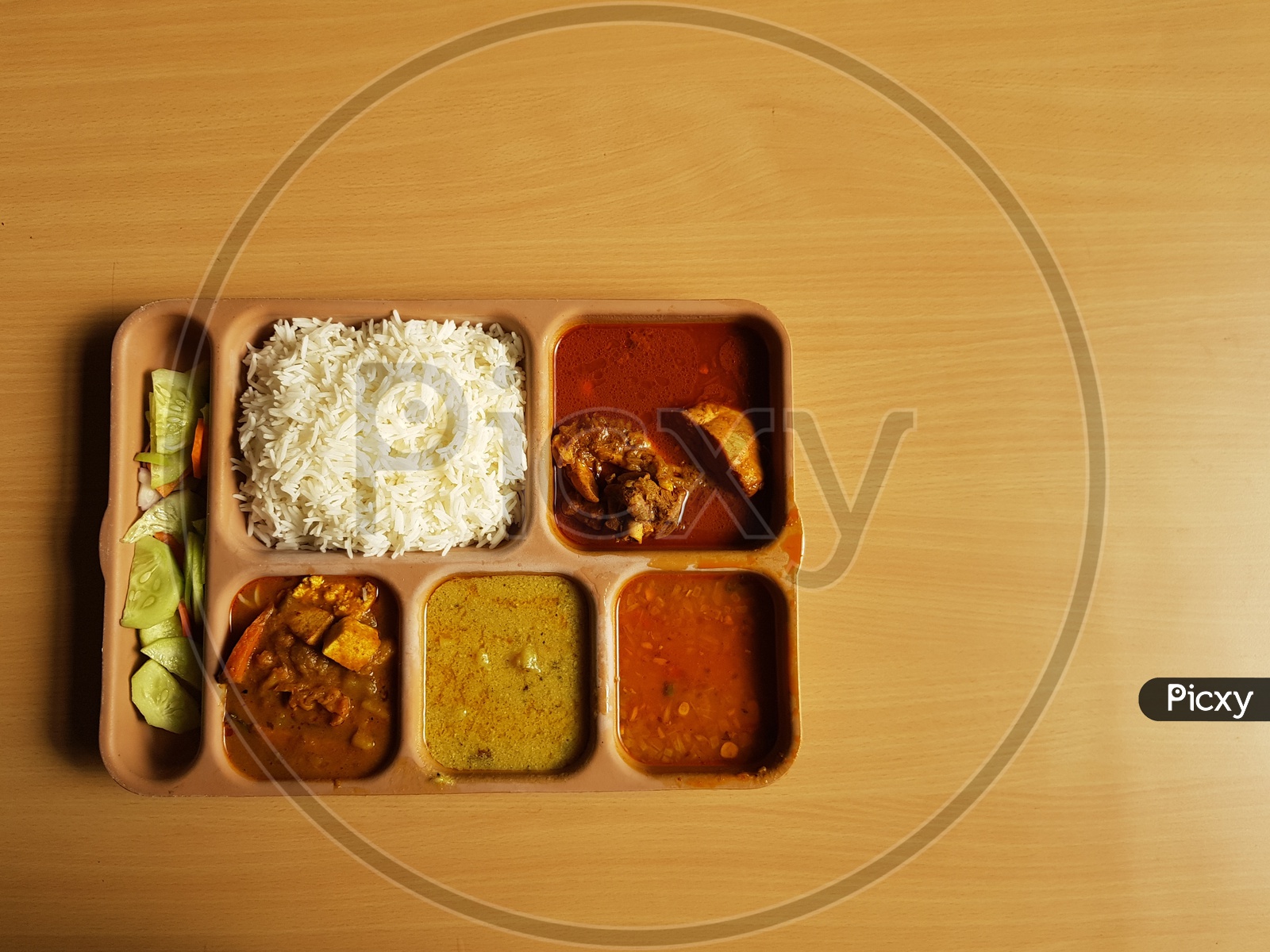 Indian Chicken Thali With Rice Dal Chicken Salad Vegetable Curry On A Plastic Segmented Plate In Wooden Background