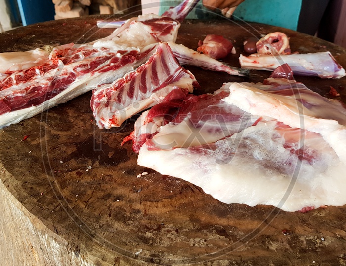 Fatty Red Meat Cut Manually On A Wooden Platform By A Butcher With A Meat Copper Knife
