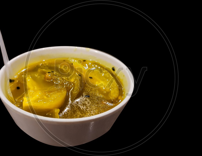 kaccha aam chutney sweet n sour unripe green mango pickle on a china clay bowl on an isolated black background with copy space for text