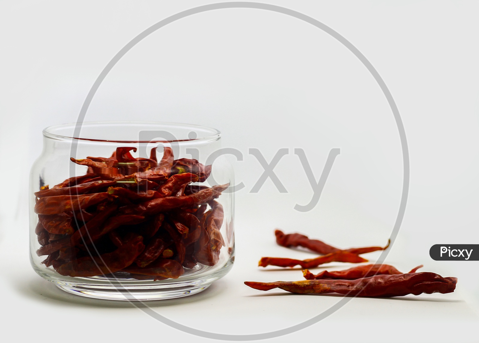 Dried Red Chilli In Glass Container In White Background