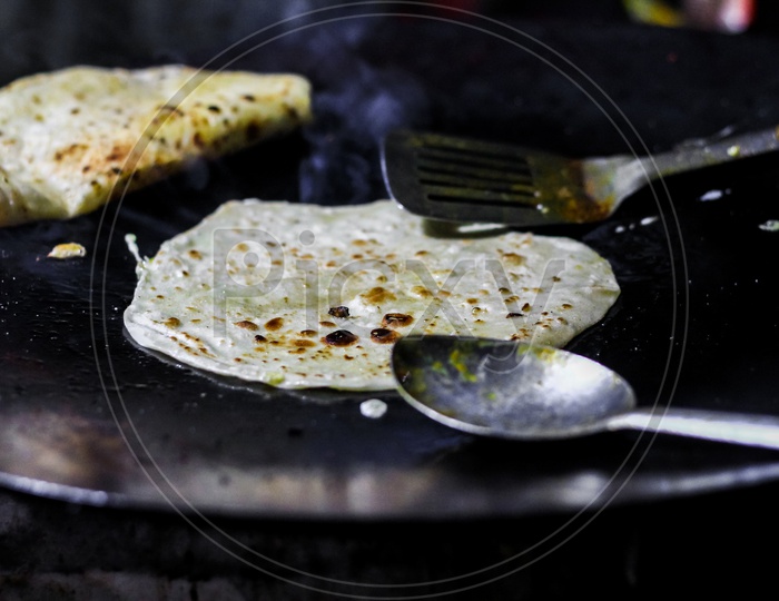Making Of Egg Roll On A Hot Frying Pan With Oil And Paratha And Salad