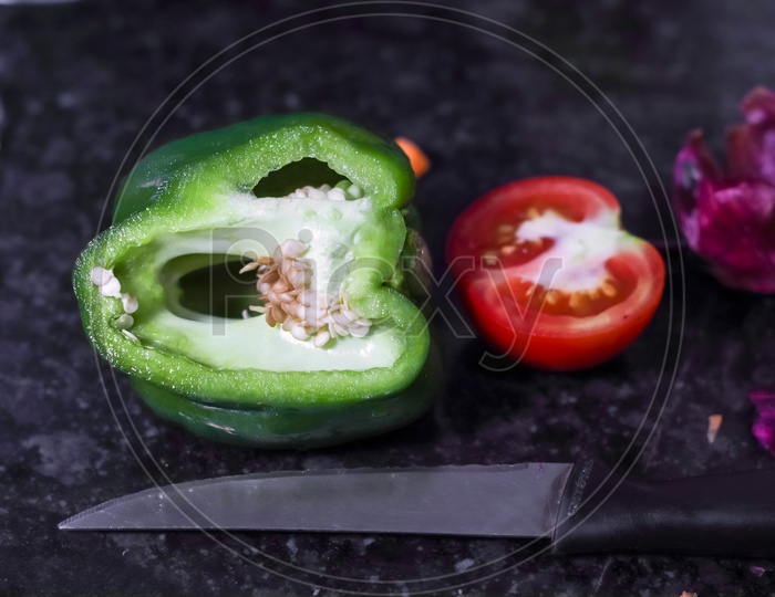 Cut Capsicum And Tomato And Knife On Granite Background