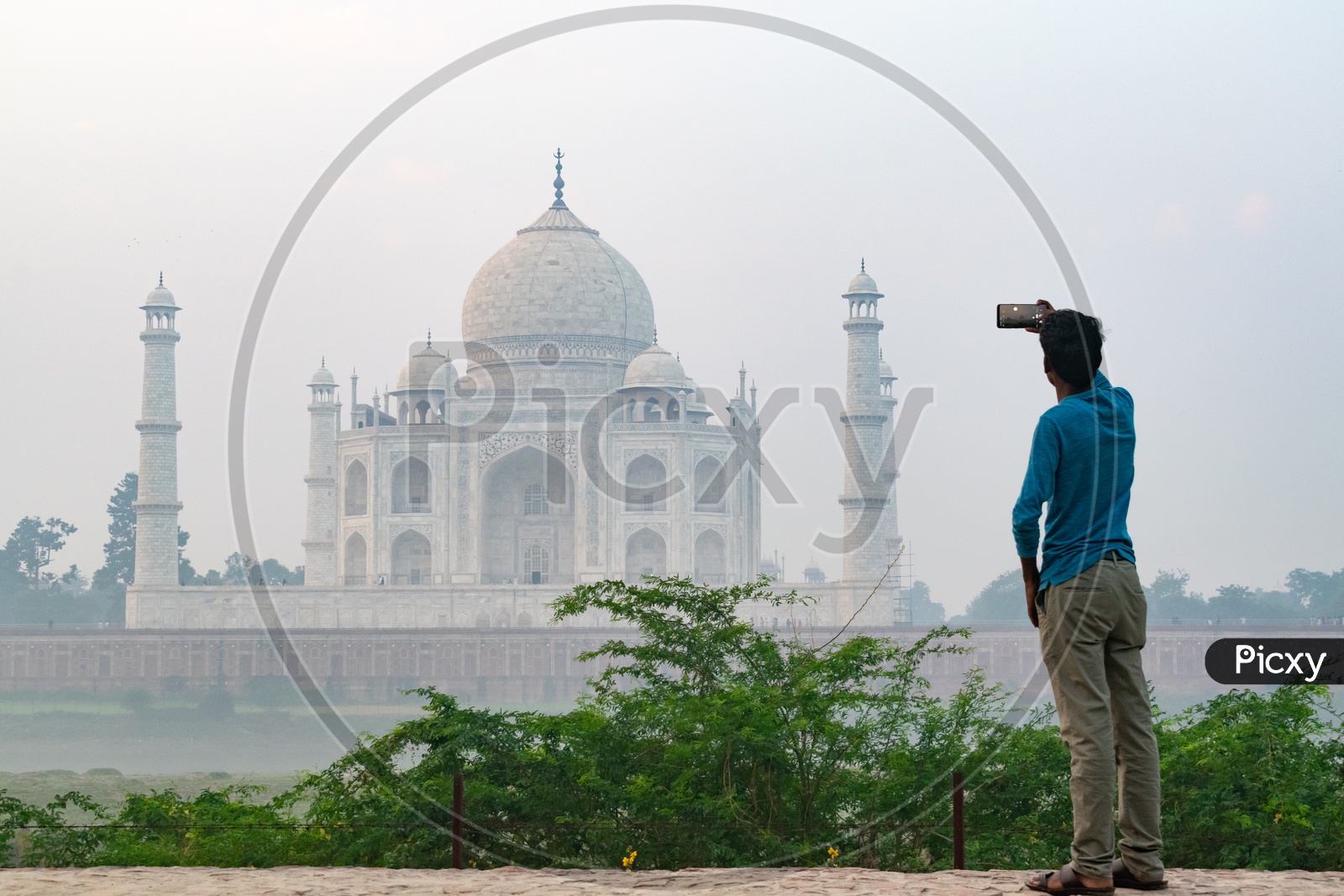 Man Capturing  Beautiful Taj Mahal on a Foggy Morning