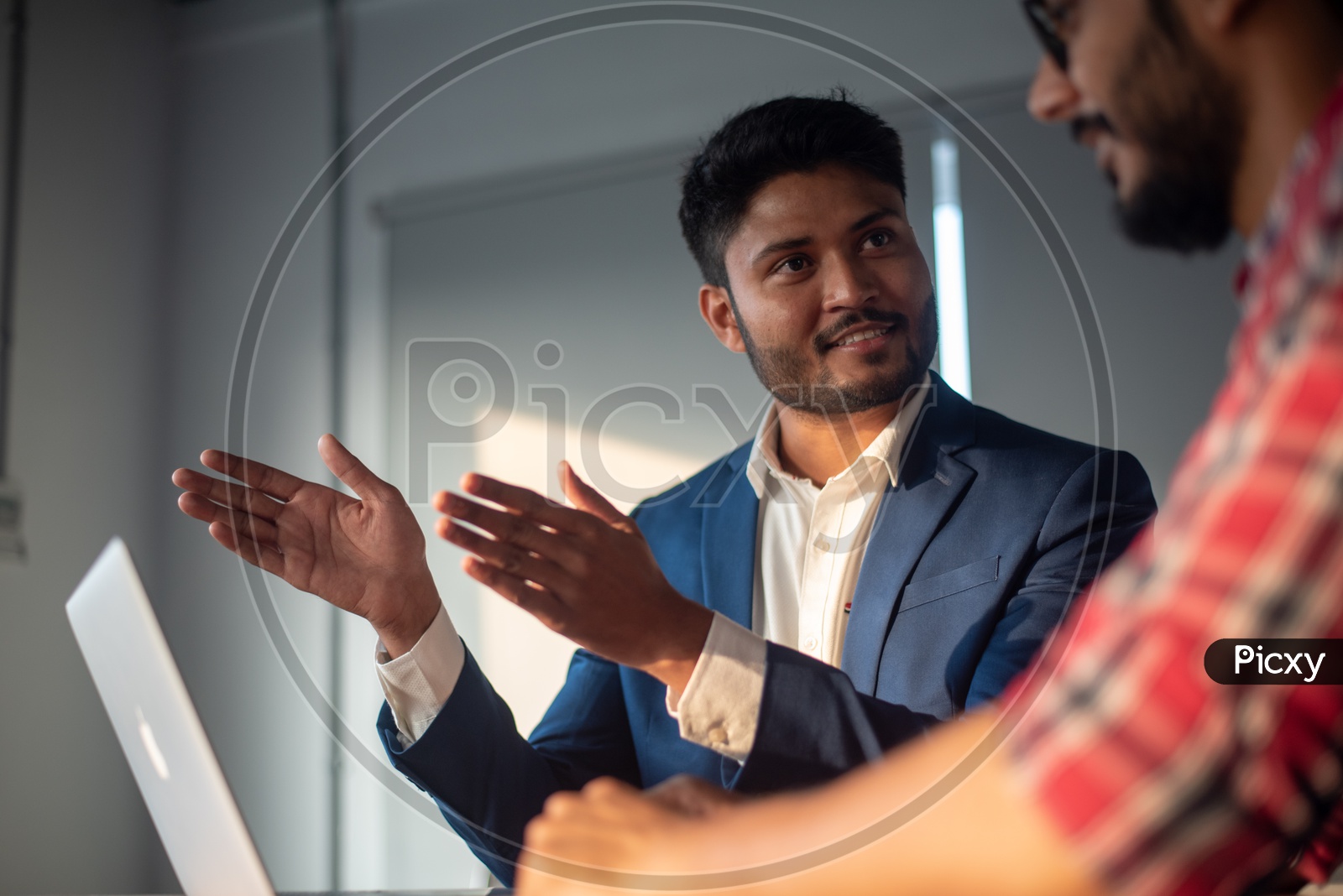 Indian Businessman Discussing Business Strategies With Employees At Office Work Space