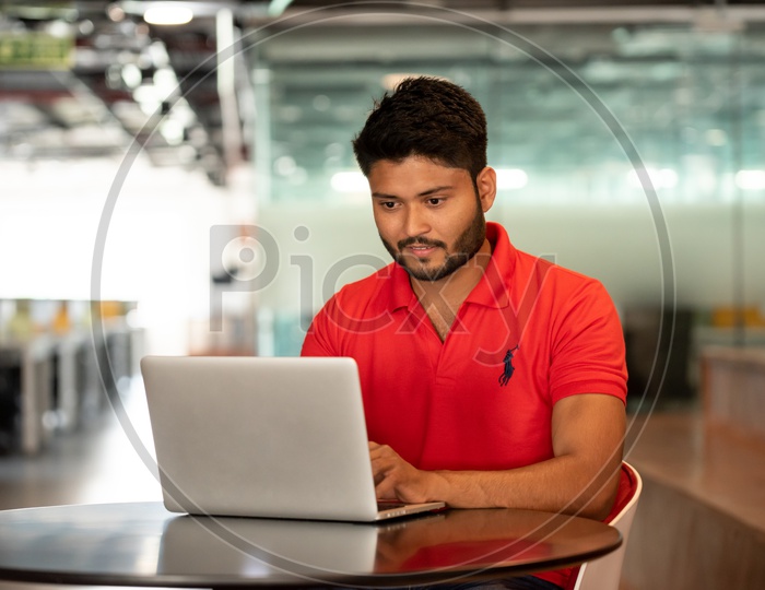 Young Indian Male Student working on Laptop