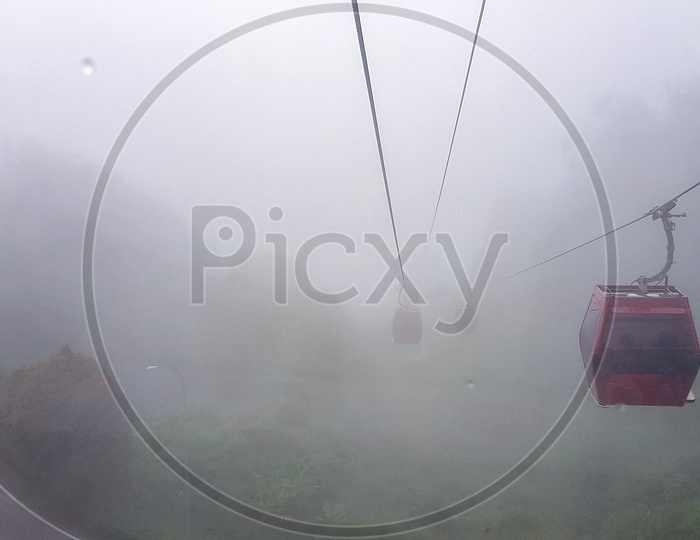 Cable Car At Genting Highlands, Malaysia In A Foggy Weather With Green Grass Visible From Inside Cable Car