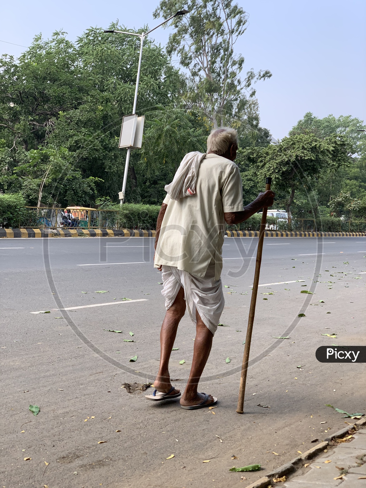 An Indian Old Man Walking on Roads With Help Of an Stick