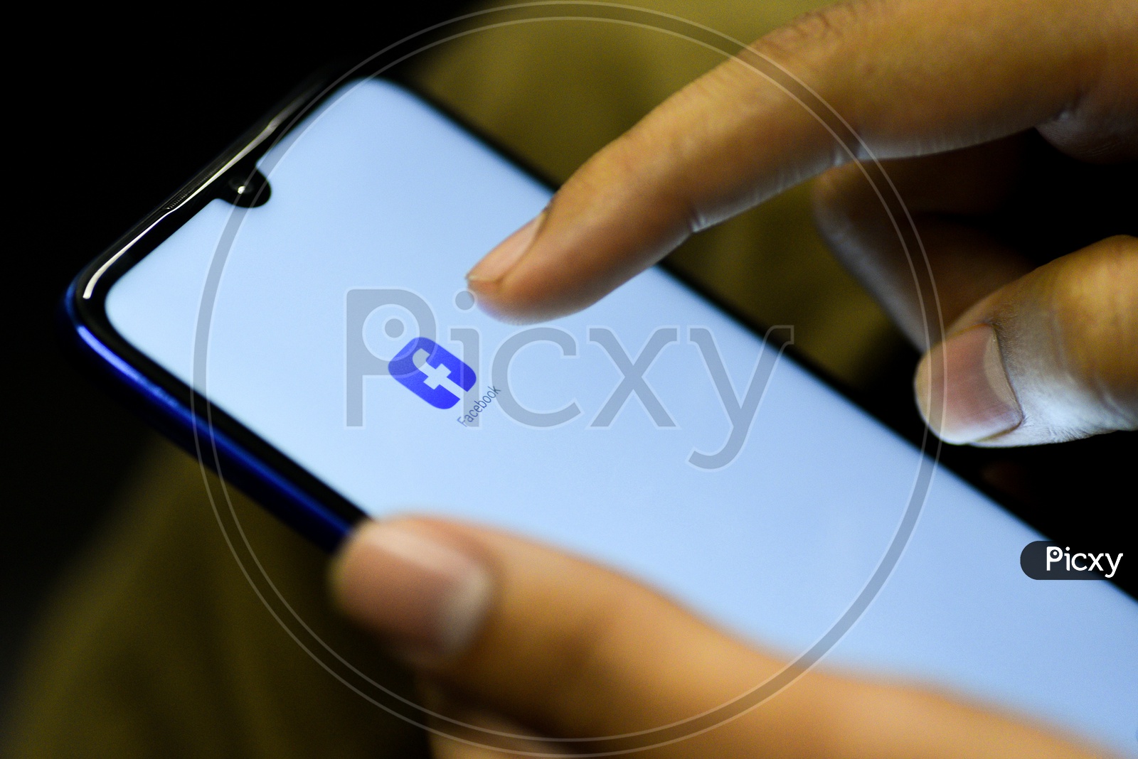 Facebook   Mobile App Icon Opening on Smartphone Screen  Closeup With Finger