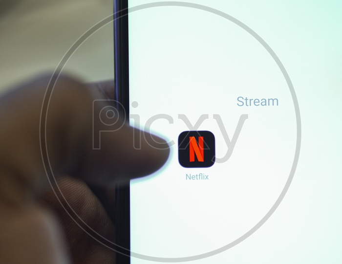 Netflix Mobile App Icon Opening on Smartphone Screen  Closeup With Finger