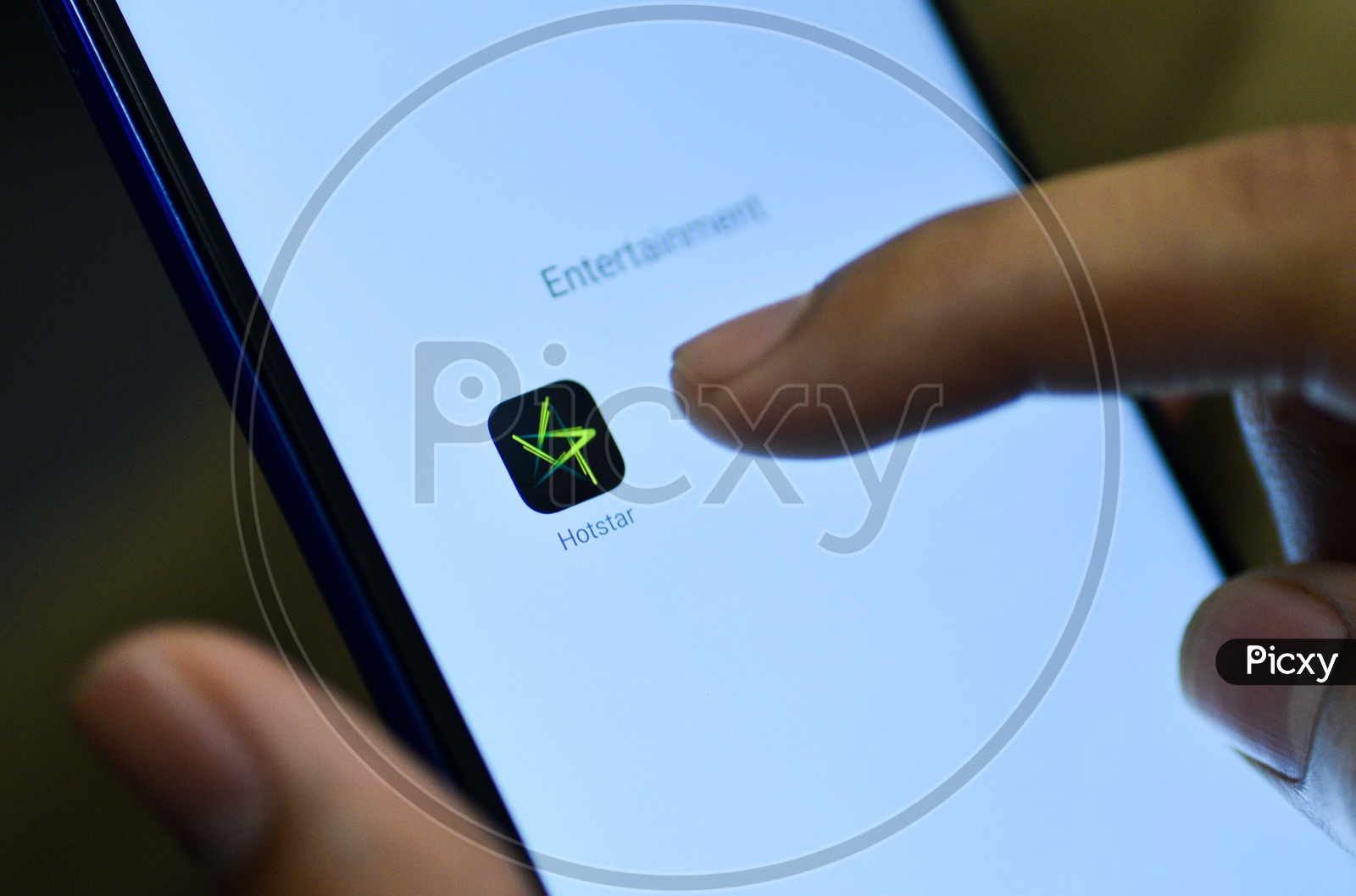 Hotstar Mobile App Icon Opening on Smartphone Screen  Closeup With Finger