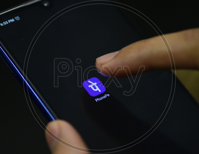 Phonepe  Online Payments Mobile App Icon Opening on Smartphone Screen  Closeup With Finger
