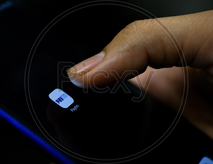 Paytm  Online Payment Mobile App Icon Opening on Smartphone Screen  Closeup With Finger