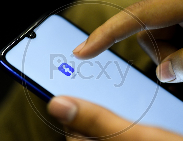 Facebook   Mobile App Icon Opening on Smartphone Screen  Closeup With Finger