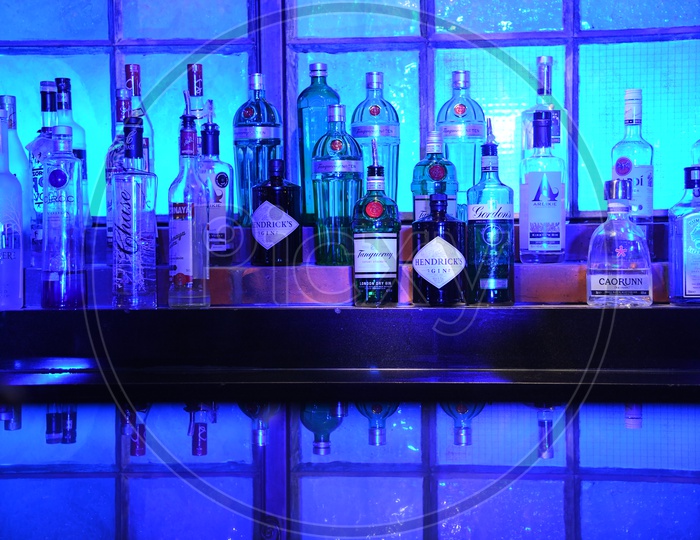 Alcohol Bottles On an Bar Counter With Neon Blue Light Ambiance