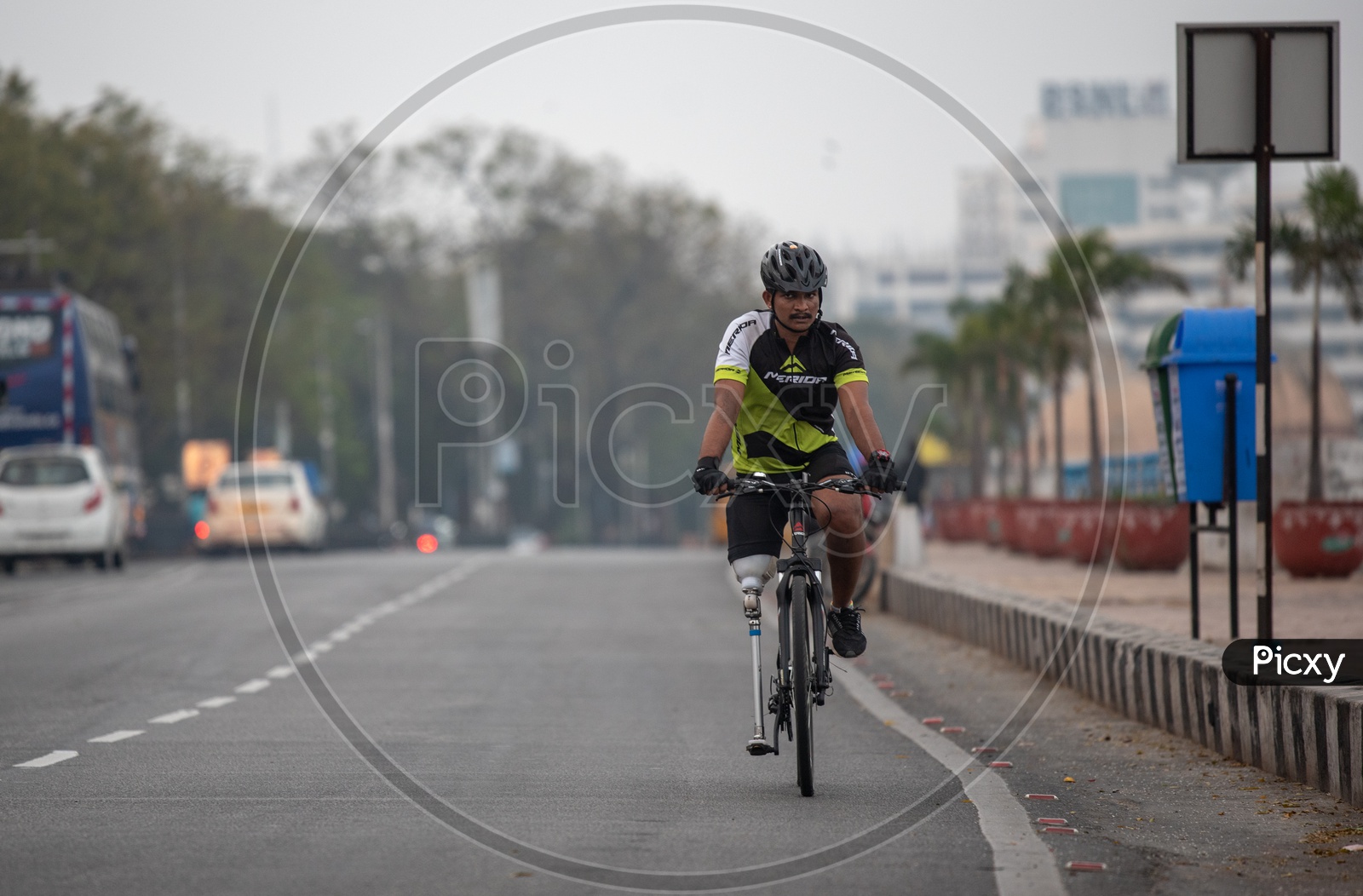 Physically Challenged Man With Leg Prosthesis Cycling on Tankbund