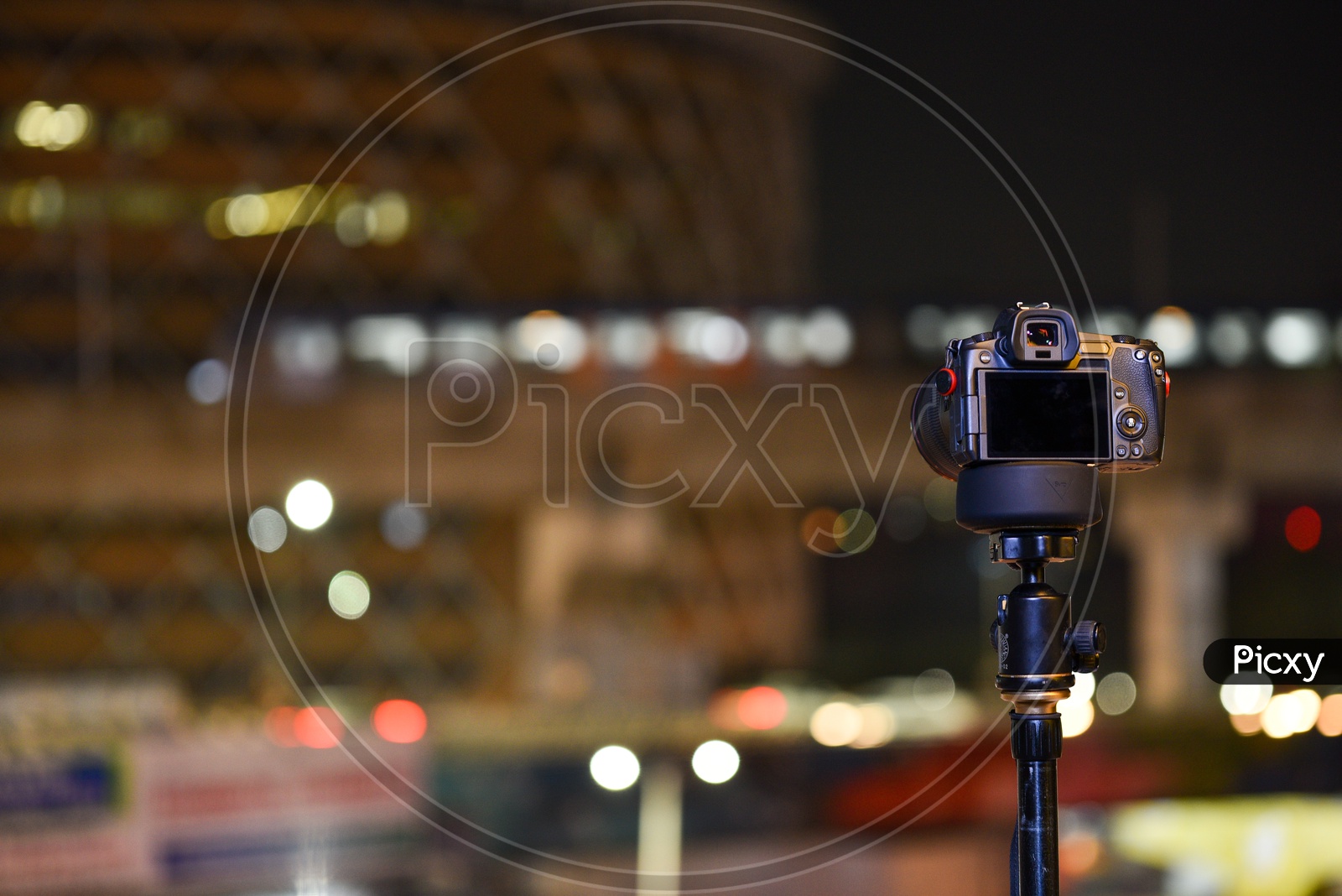 DSLR Camera Mounted to a Tripod With Cyber Towers Bokeh Background
