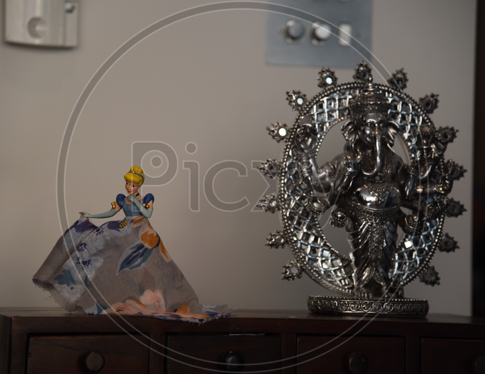 Cinderella Doll and  Lord Lord Ganesh Idol On an Table