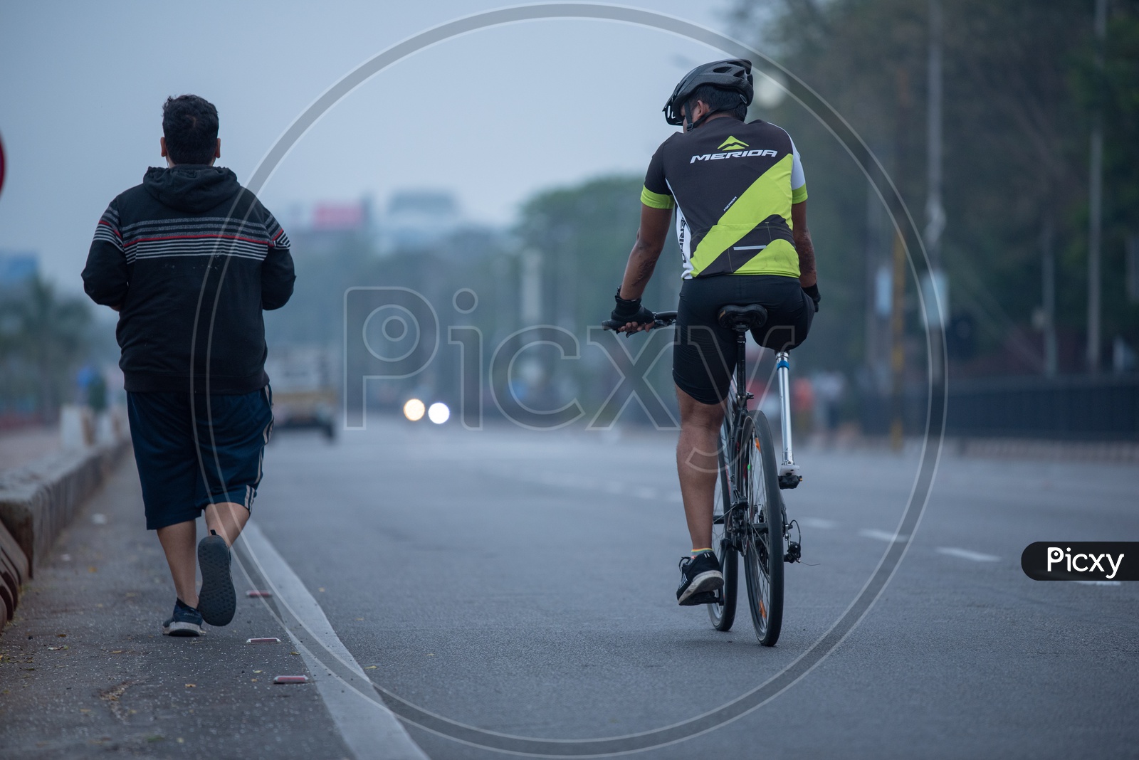 Physically Challenged Man With Leg Prosthesis Cycling on Tankbund