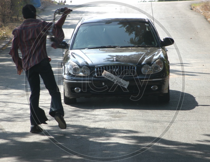 Man Braking Moving Car Glass In a Movie Working Stills