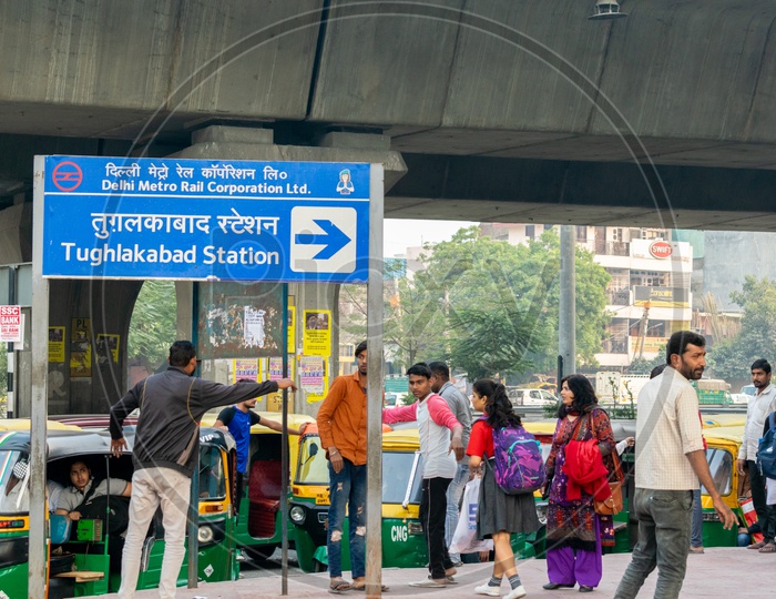 Tughlakabad Metro Station sign board and Auto rickshaw drivers calling the passengers