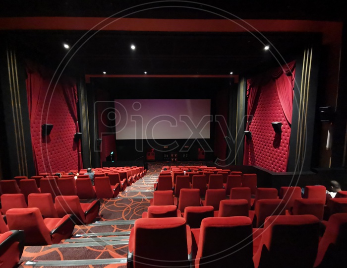 Empty Movie Theater Auditorium With With Screen And Red Seats in Rows