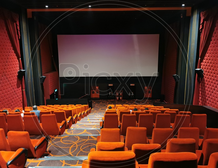 Empty Movie Theater Auditorium With With Screen And Red Seats in Rows