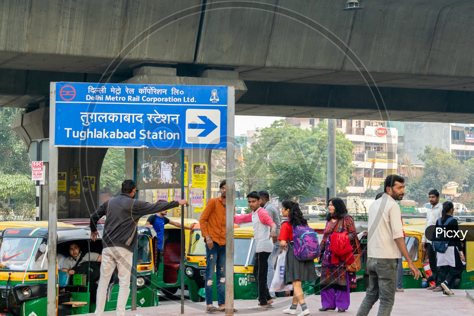 Tughlakabad Metro Station sign board and Auto rickshaw drivers calling the passengers