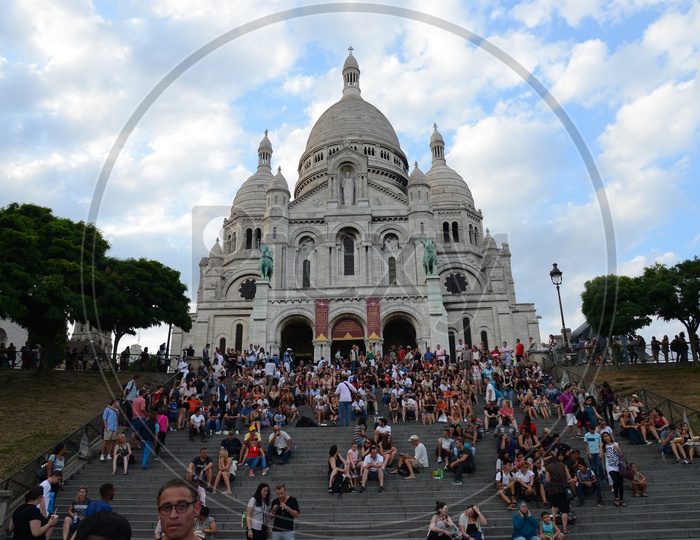 Sacré-Cœur Basilica , Also Called As The Basilica of the Sacred Heart of Paris A Roman Catholic Church In Paris With  Busy Visitors Sitting on Steps