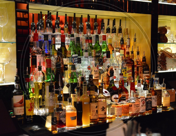 Alcohol Bottles In Rows At a Bar Counter