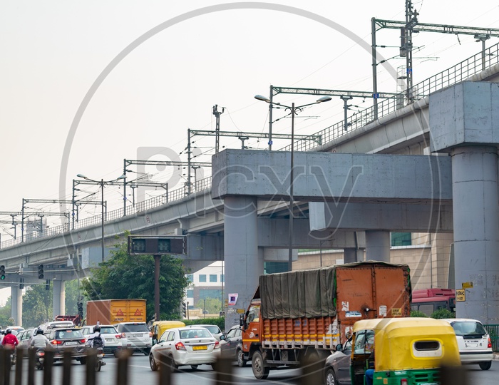 Delhi metro line over bridge and vehicles on road