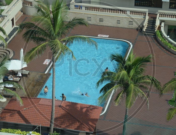 Aerial View Of A Swimming Pool With Swimmers In a Hotel