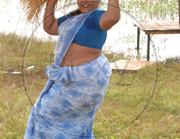 Image of Indian woman wearing pink top and bell bottom jeans