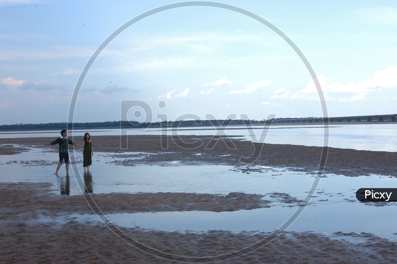 Indian Couple or Lovers Walking on Sand near a River