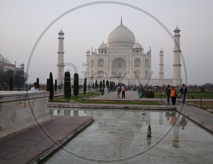 Beautiful View Of Taj Mahal With Tourists At Fountain