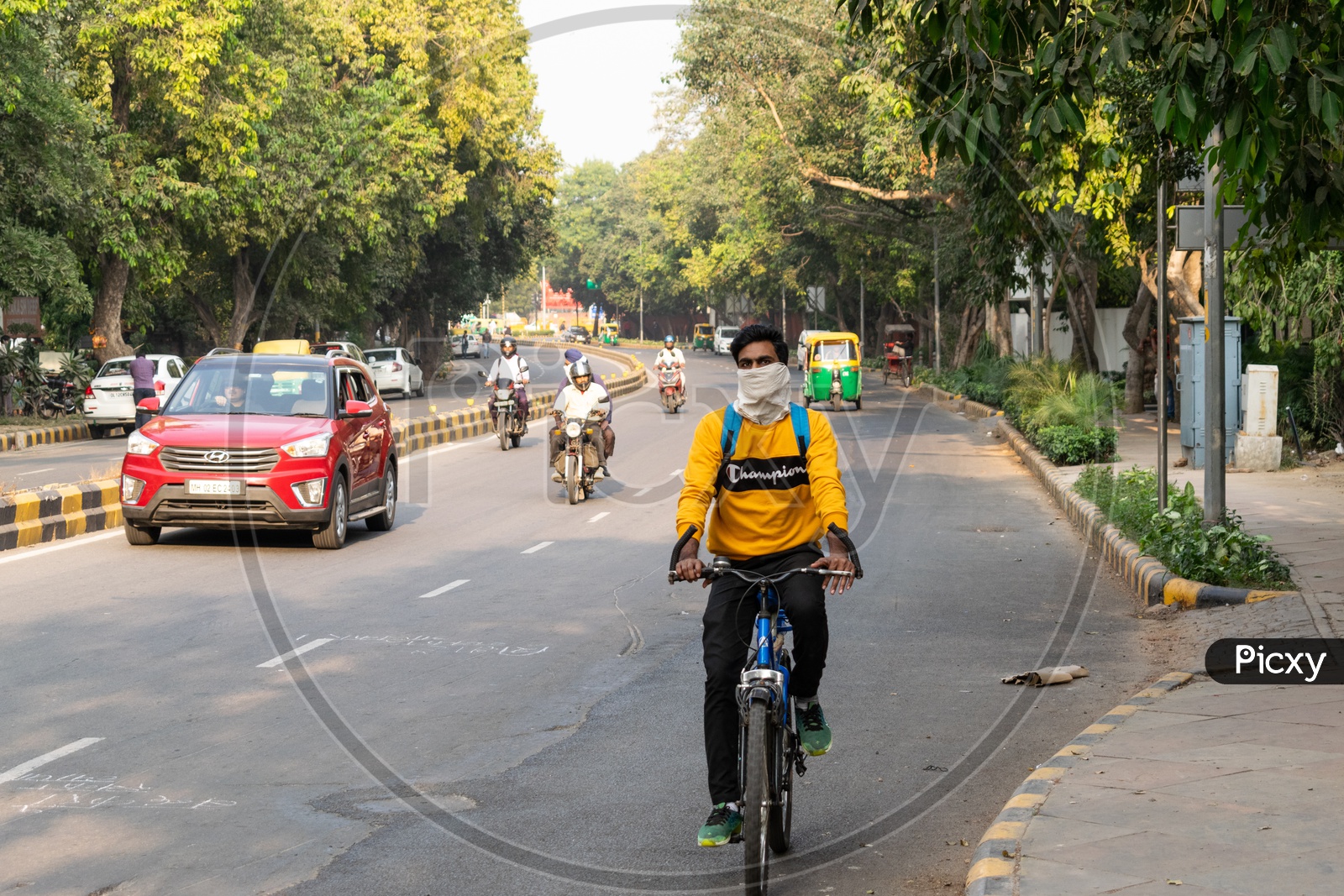 A man riding bicycle, covering his face with handkerchief to avoid pollution