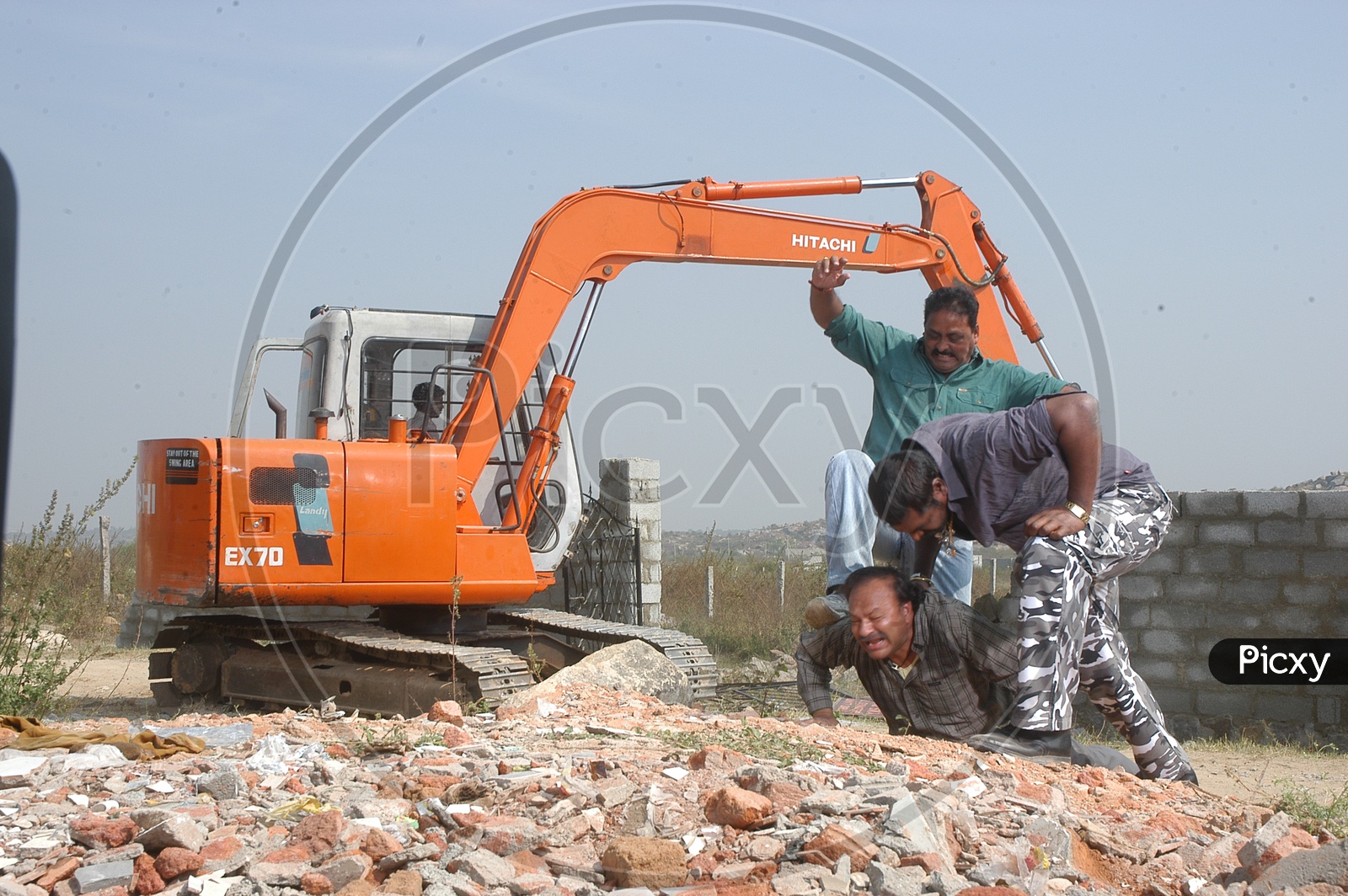 A Proclainer Demolishing Protective Walls around a Vacant Land