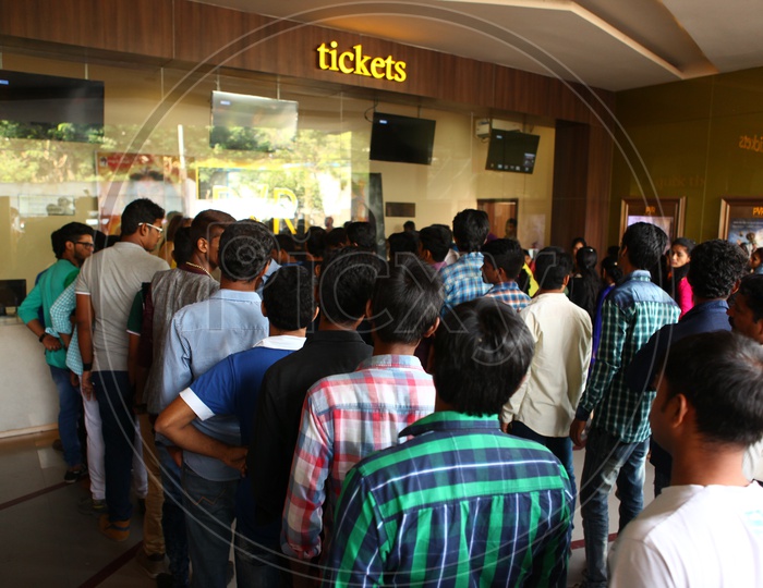 Crowd Of People In Queue Lines At Ticket Counter In a Theater