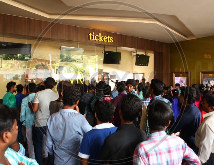 Crowd Of People In Queue Lines At Ticket Counter In a Theater