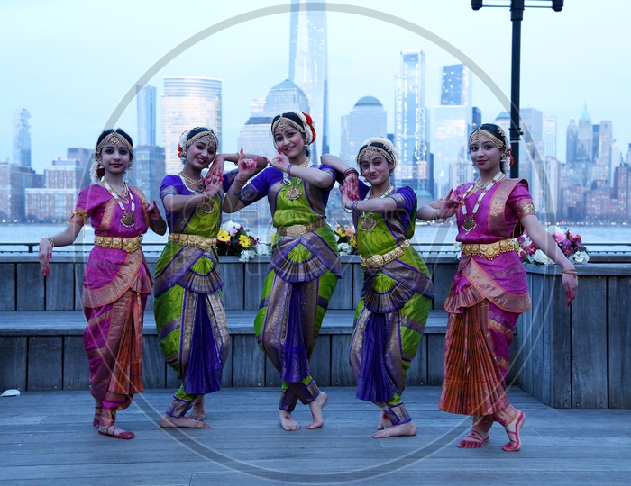 Indian Classical Dancers  On Eastern River Bank In New York With High Rise Building Blocks In Background