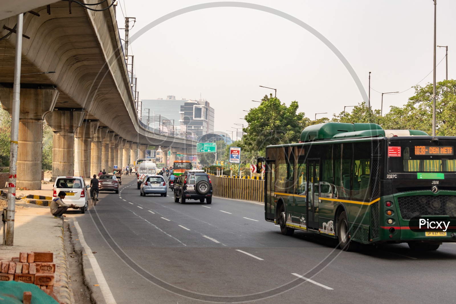 Delhi metro line passing over a road and Noida Metro Rail Corporation Bus