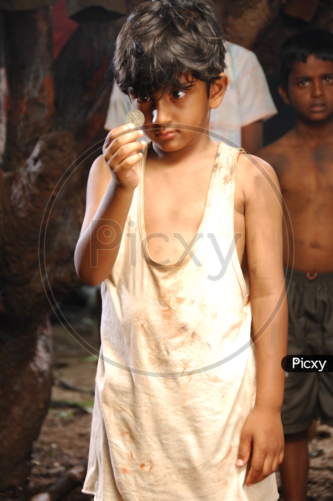 Tollywood Child Artist Holding And an Indian Coin in Hand  In Movie Working Stills