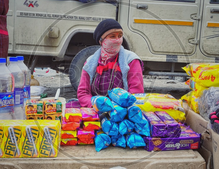 Shop keeper in mountains selling maggi and biscuits.