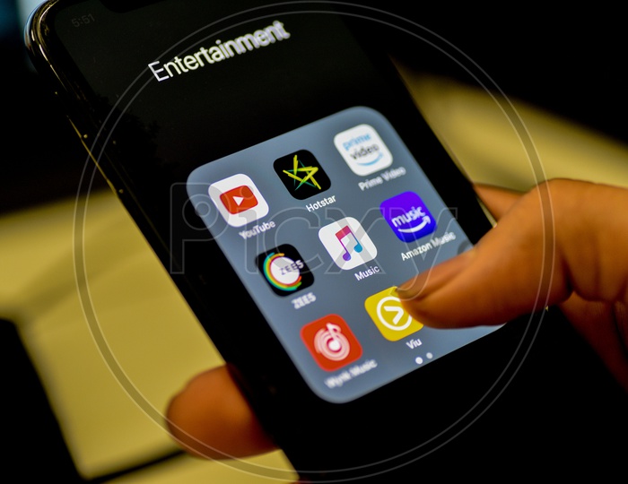 Entertainment Online Streaming Apps Installed Icons  On a Smartphone Screen Closeup With Man Finger Opening ViU App