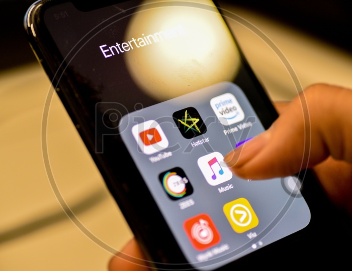 Entertainment Online Music  Streaming Apps Installed Icons  On a Smartphone Screen Closeup With Man Finger Opening   Music App