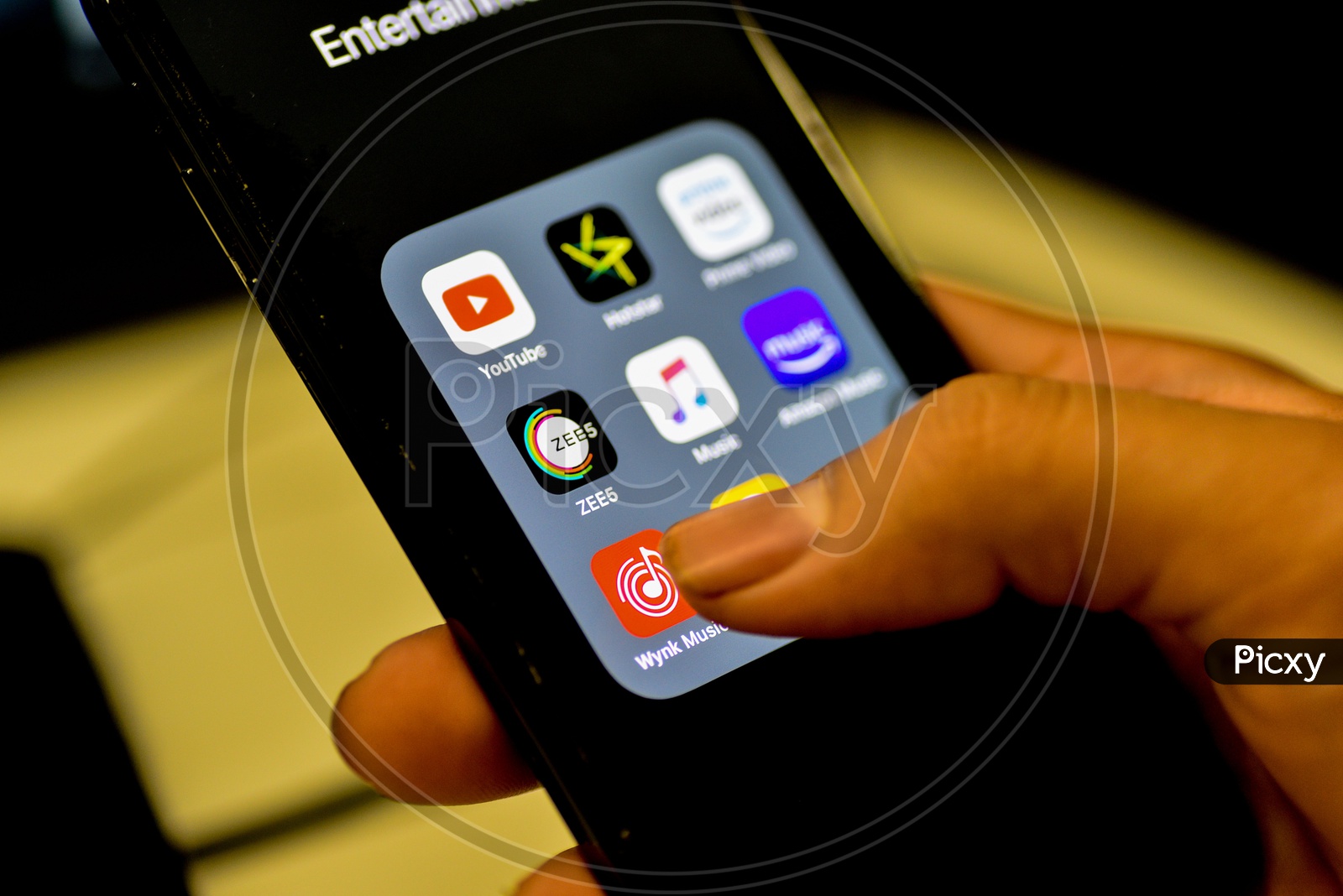 Entertainment Online Music Streaming Apps Installed Icons  On a Smartphone Screen Closeup With Man Finger Opening Wink music  App