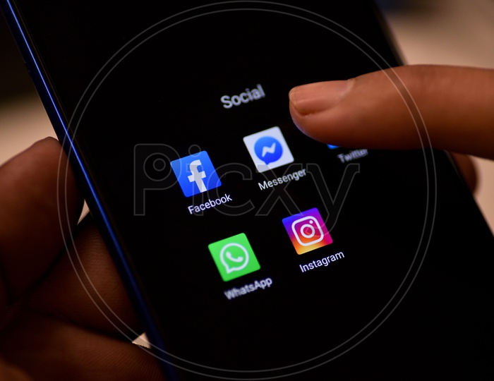 Social Networking Apps Installed Icons On a Smartphone Screen Closeup With Man Finger Opening Facebook Messenger App